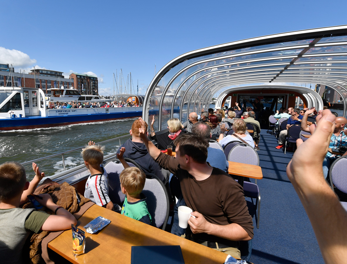 winkende Menschen bei einer Hafenrundfahrt auf dem Schiff in Bremerhaven