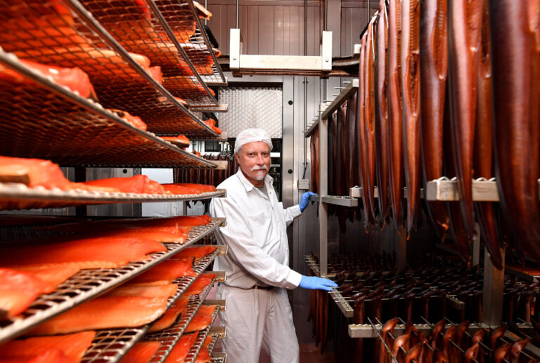 Mann in Kamera blickend in einer Fischräucherei