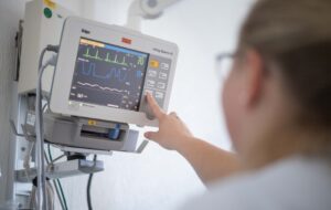 Pflegepersonal im Bremerhavener Klinikum Reinkenheide. Im Bild: Gesundheits- und Krankenpflegerin Karolina Brunnert fährt ein Patientenbett durch die Gänge der Station 11 A im Klinikum und überprüft die Herzfrequenz am Monitor eines Patienten.