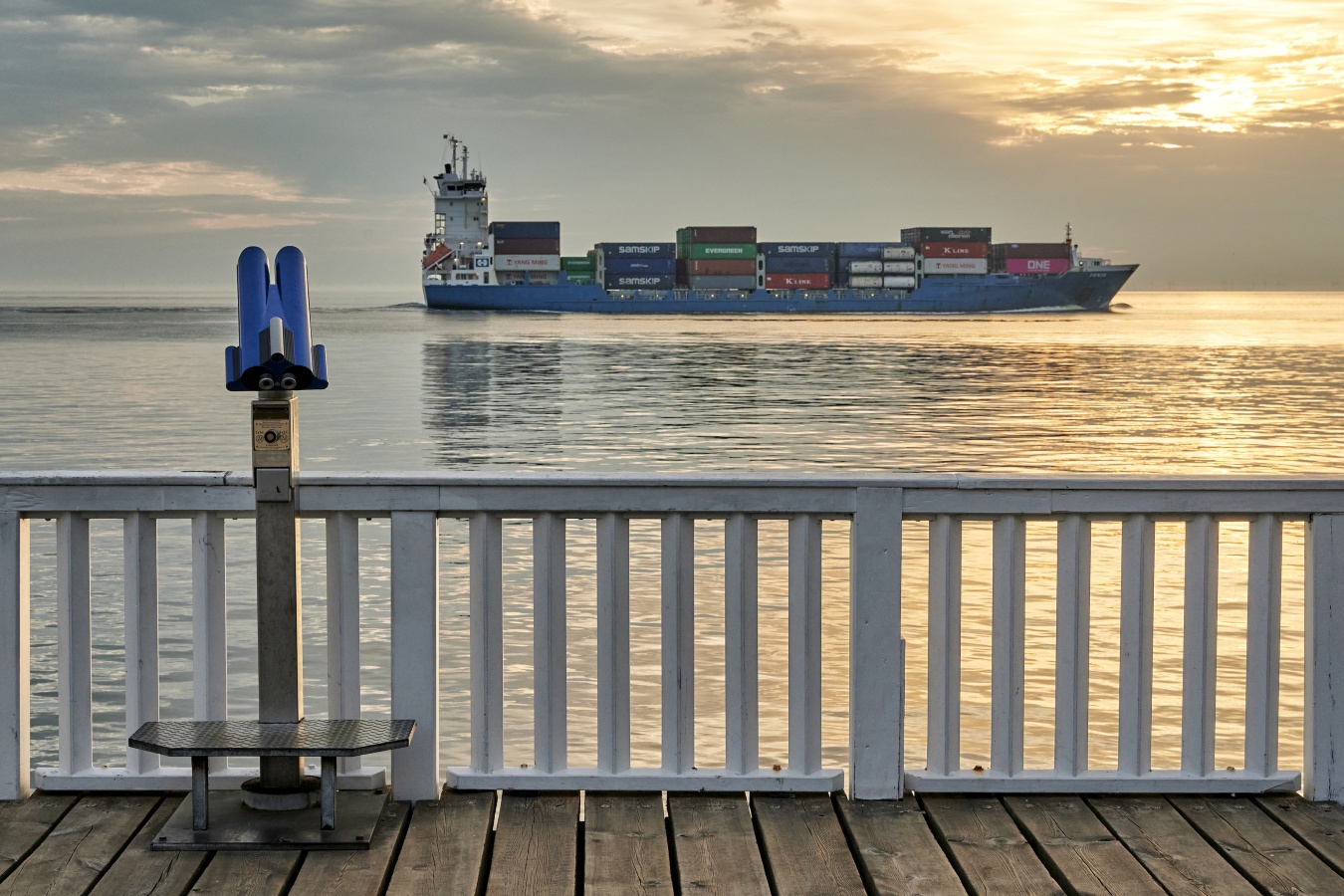 Containerschiff bei Sonnenaufgang auf Elbe vor Alten Liebe in Cuxhaven