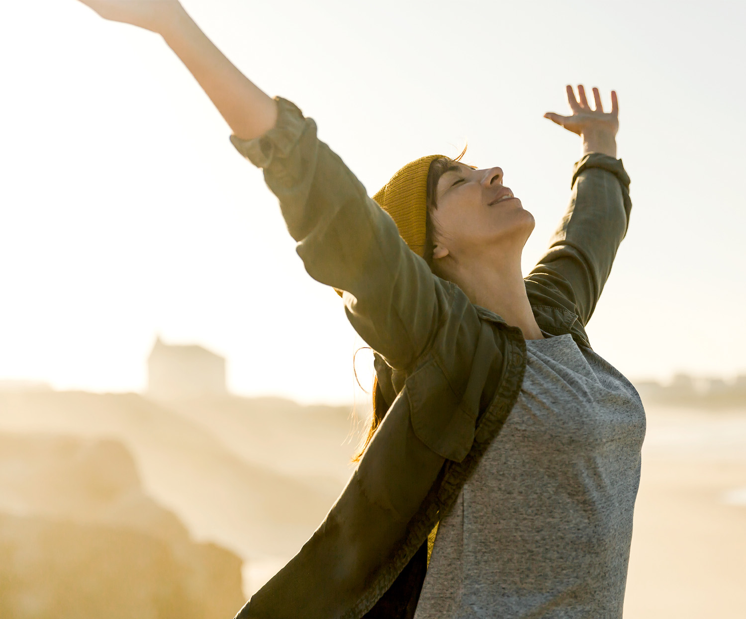 Frau Glüklich im gegenlich mit Armen nach oben
