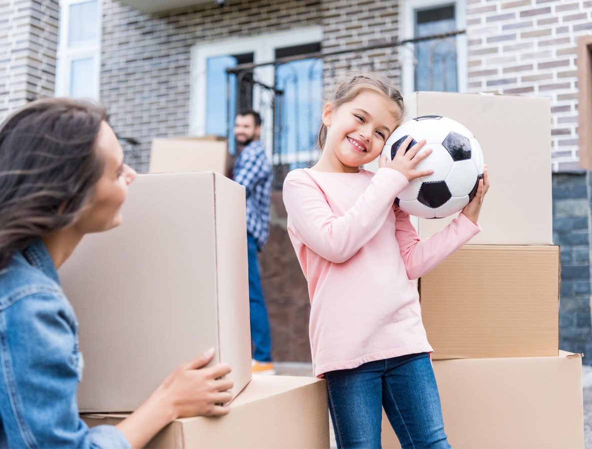 Kind im Mittelpunkt mit Ball mit Umzugskarton