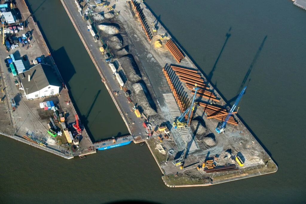 Die Hafengesellschaft Bremenports lässt entlang des neuen Kajenverlaufs der Westkaje Stahlrohre in den Boden einvibrieren, die später mit Beton verfüllt werden.