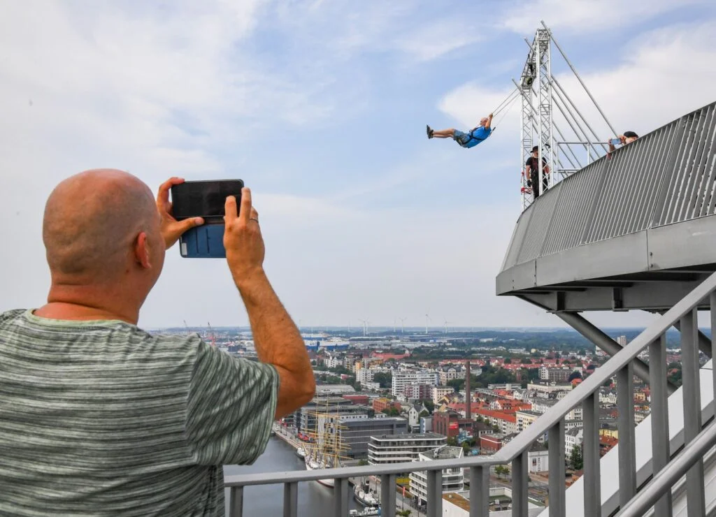 Der Bremerhavener Roland Kuhring ist der erste zahlende Gast auf der High Swing-Schaukel 86 Meter über den Havenwelten. Das muss sein Bekannter Oliver Boek natürlich filmen.