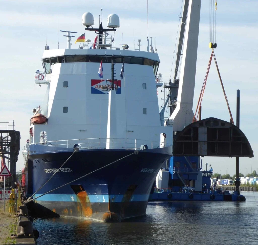 Das niederländische Schwergutschiff „Western Rock“ hat mehrere Stahl-Großsektionen nach Bremerhaven geliefert. An der Labradorkaje, direkt vor der Lunehalle von Stahlbau Nord, wurden sie mit dem Schwimmkran „BHV Athlet“ entladen.